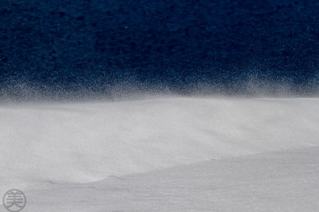 Blowing snow with dark blue surface of Crater Lake.